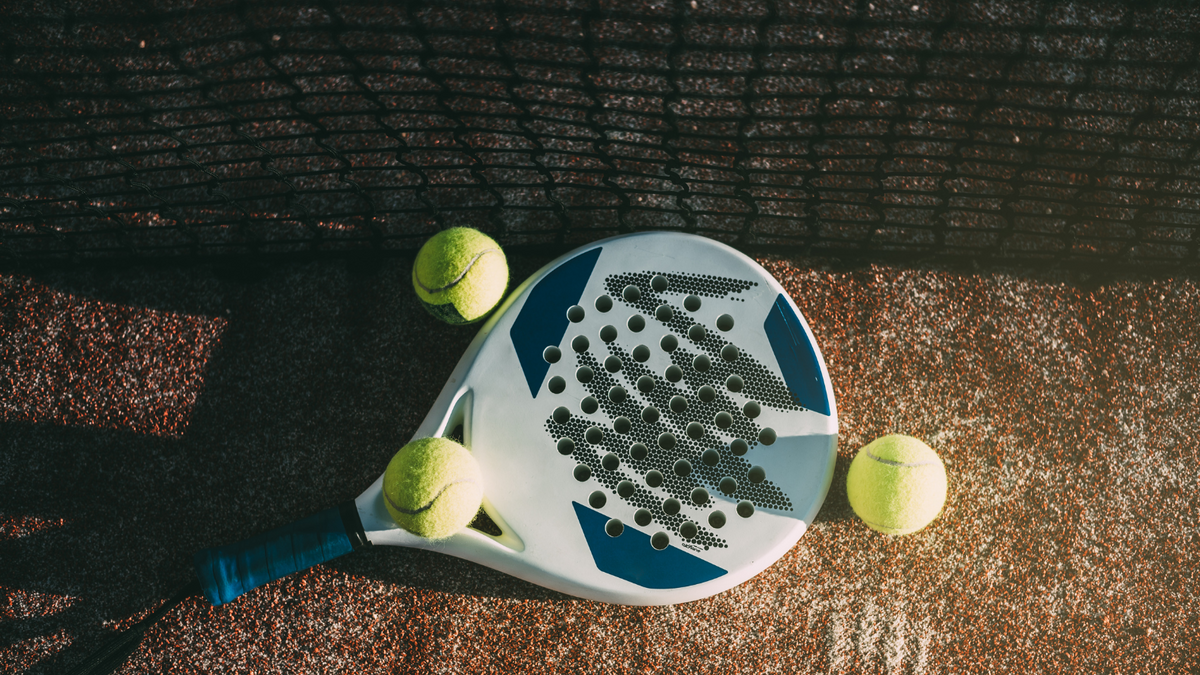 Padel racket and balls on a court