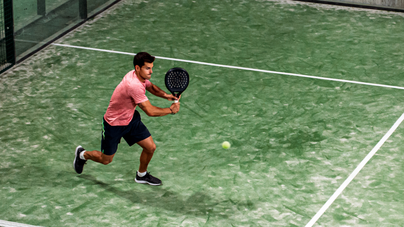 A player returning a shot on a padel court