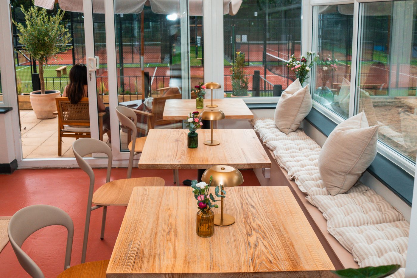 Inside Yetz Café at The Ponsbourne Club: a bright conservatory with wooden tables