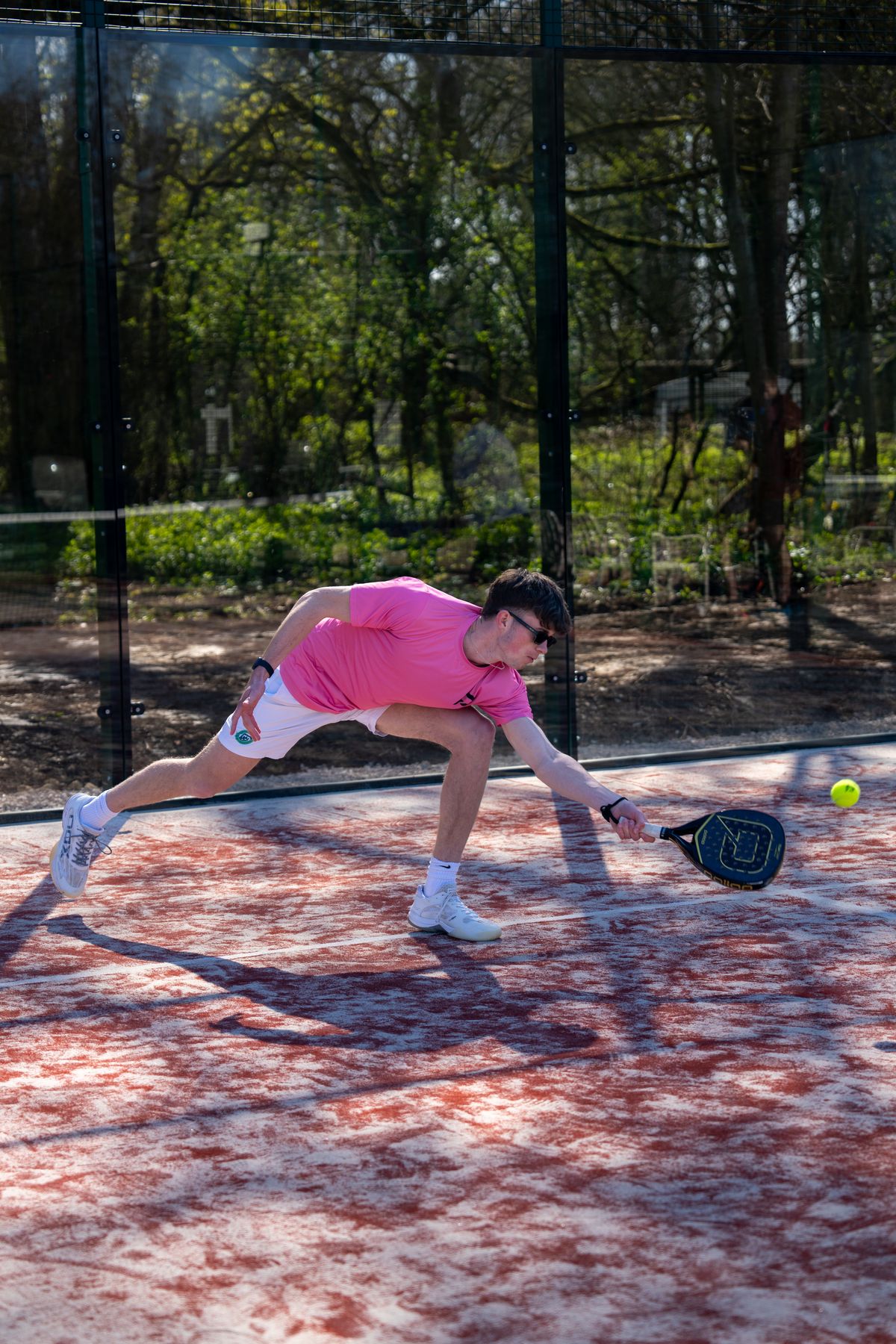 Padel X coach stretching for a low ball on court